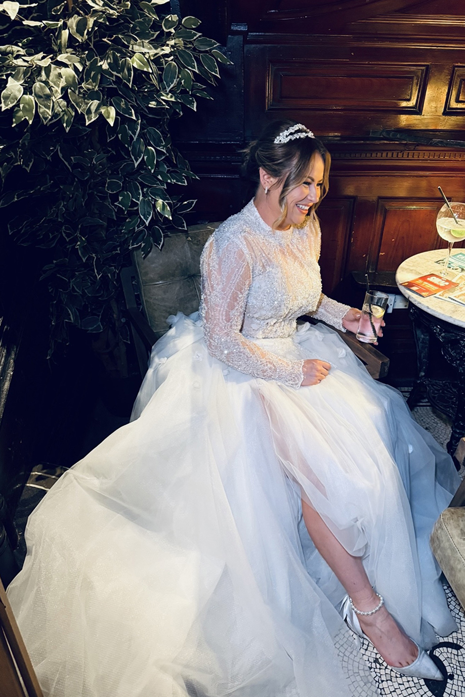 Bride smiles as she sits at table, captured by wedding content creator in Scotland Unveiled Moments